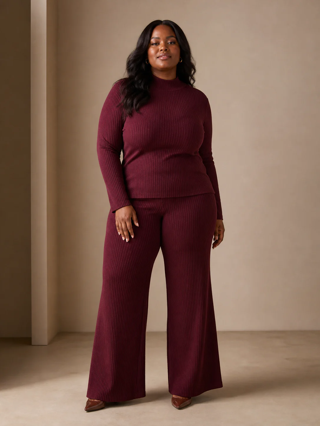 Plus-size Black model wearing a burgundy rib-knit top and wide-leg trouser set