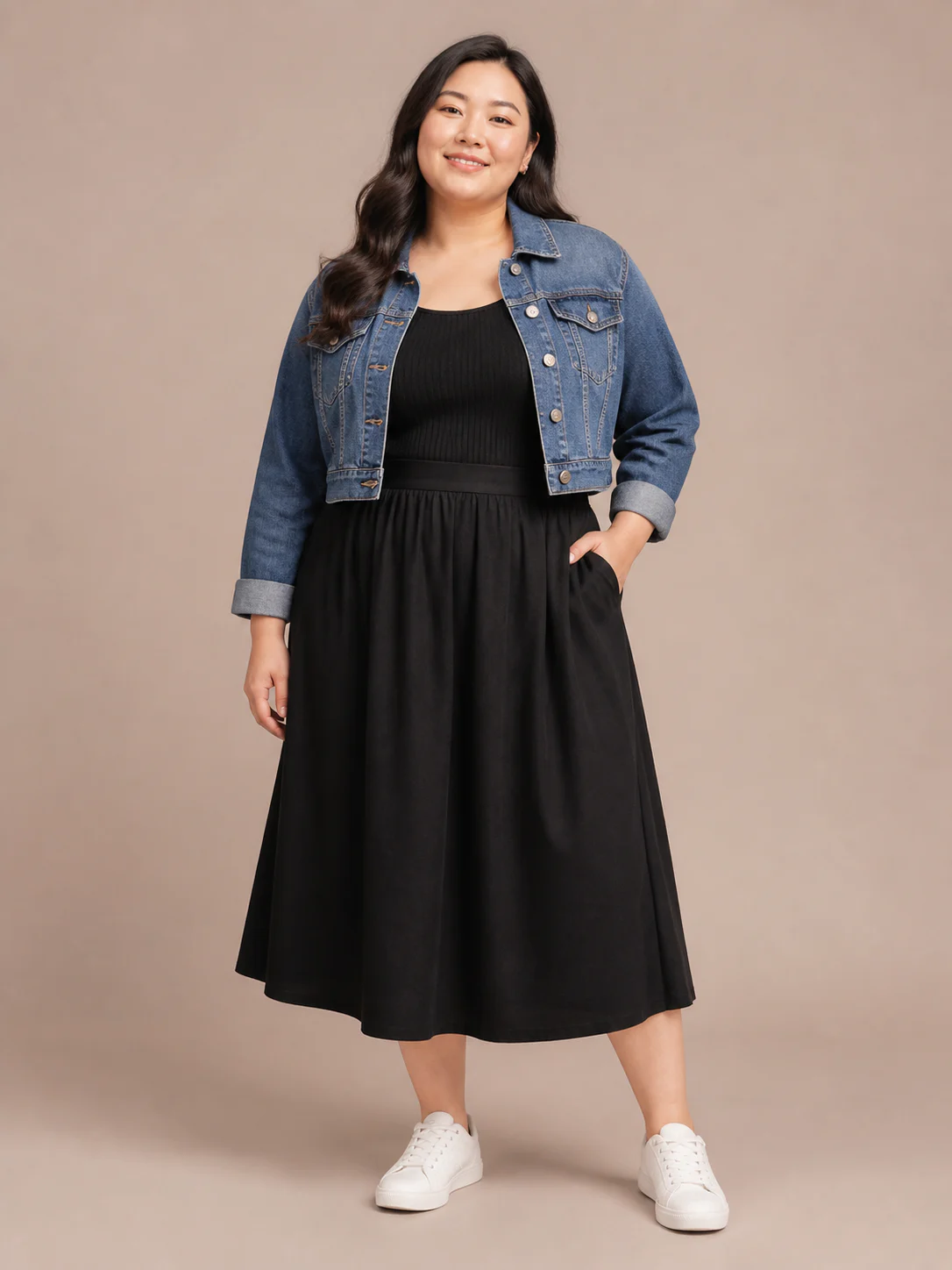 Plus-size East Asian model wearing a denim jacket with a black midi skirt