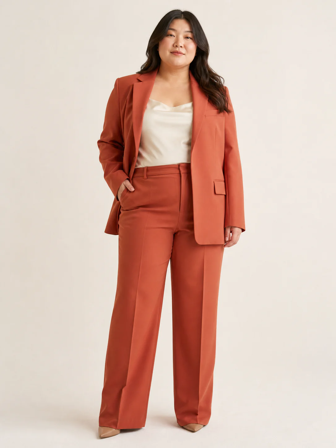 Plus-size East Asian model wearing a terracotta blazer and wide-leg trouser suit